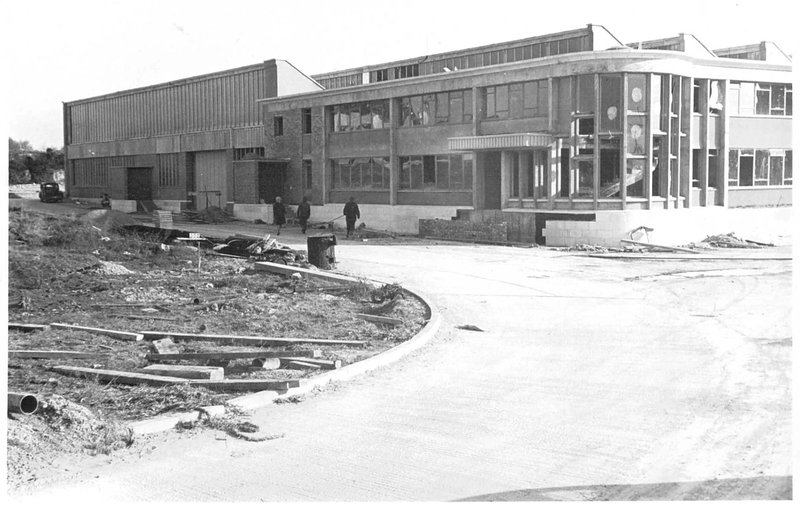 The factory front entrance area with construction materials still visible
